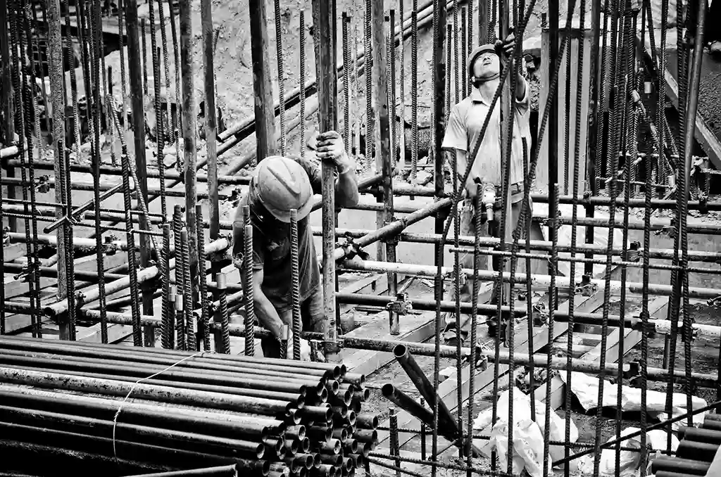 Construction workers assembling steel frameworks, illustrating key steps in the construction process during various Architecture Project Phases.