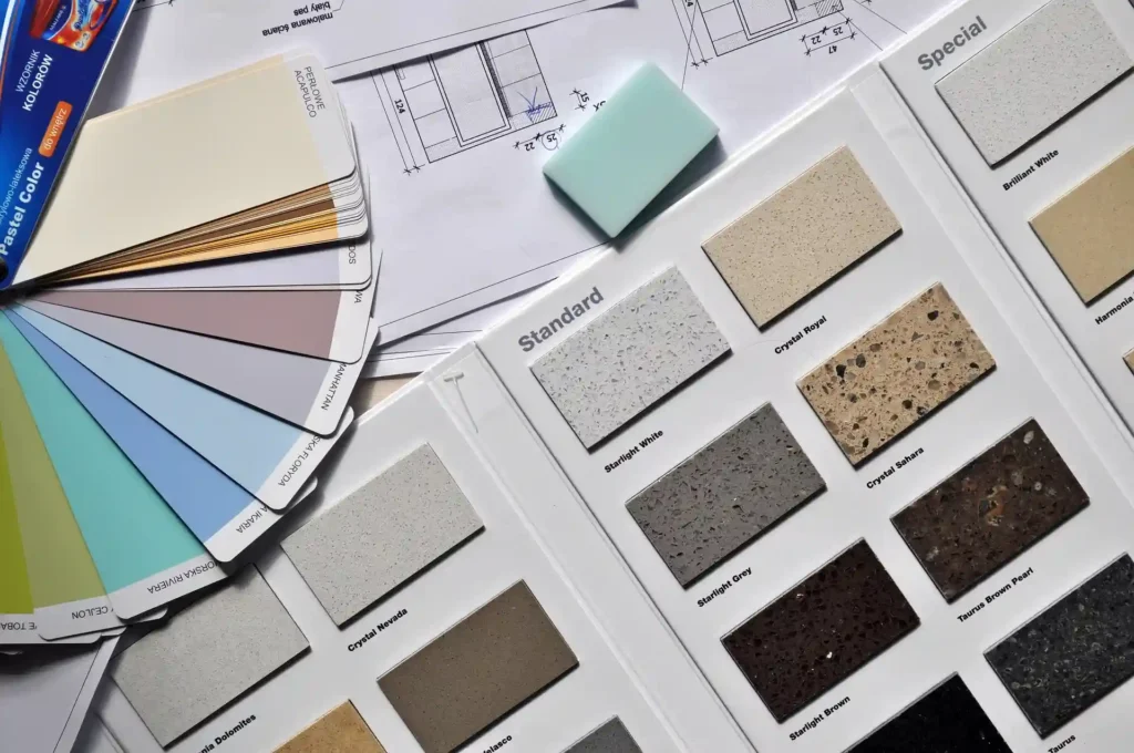 Color swatches, material samples, and architectural drawings laid out on a table, representing the selection process during the developed design phase.