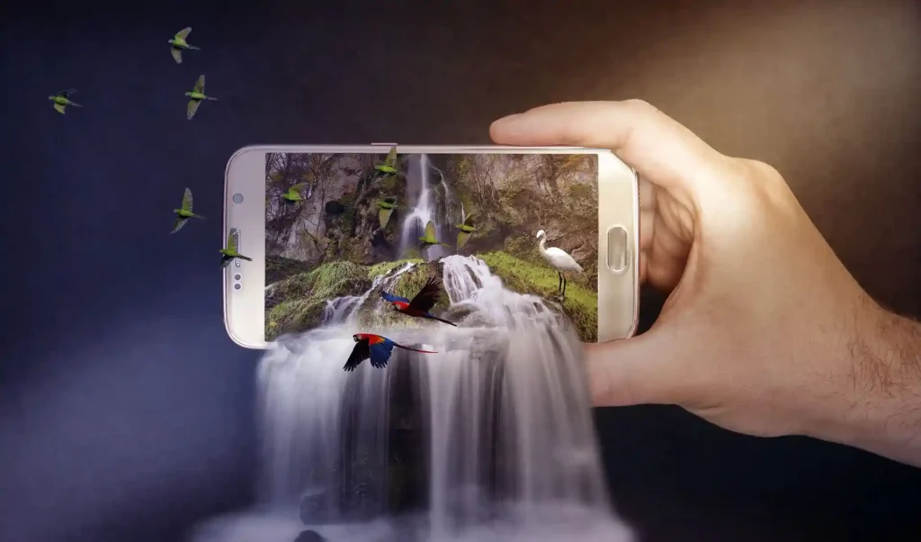 Creative concept of a smartphone displaying a vibrant natural scene, with elements like birds and a waterfall extending beyond the screen, illustrating advanced image manipulation techniques.