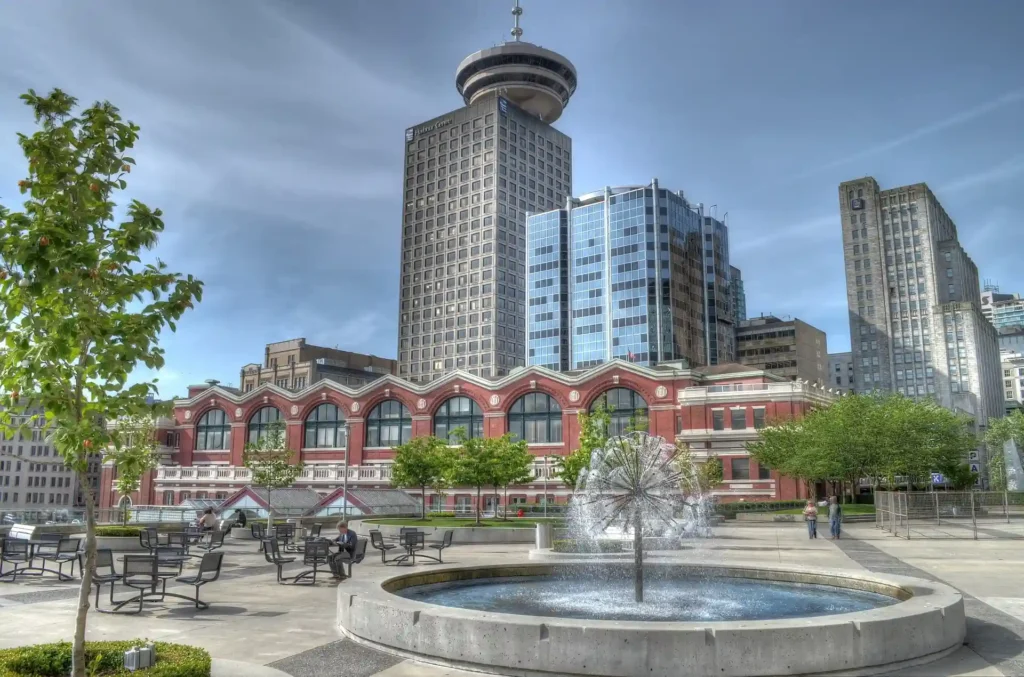 Urban plaza featuring a water fountain, trees, and modern architecture in the background, showcasing the results of urban planning software for designing public spaces